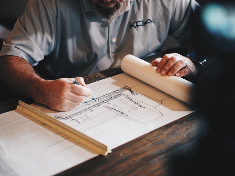Planner reviewing architectural site plans with ruler